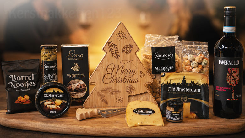 Kerstpakket met kerstboom kaasplank, Old Amsterdam kaas, rode wijn en luxe borrelproducten.